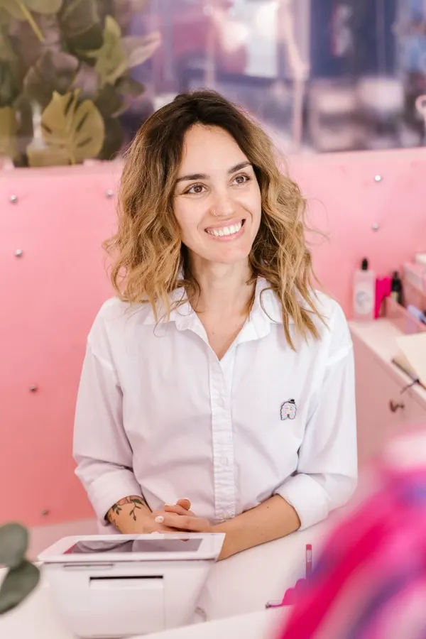 Sofia Ramirez smiling behind the salon's front desk